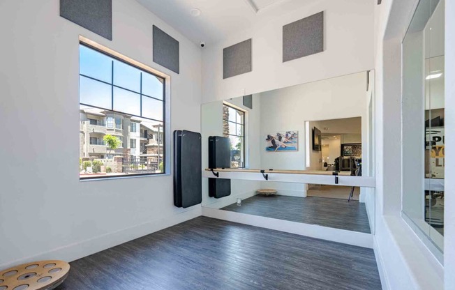a home gym with a large window and hardwood floors