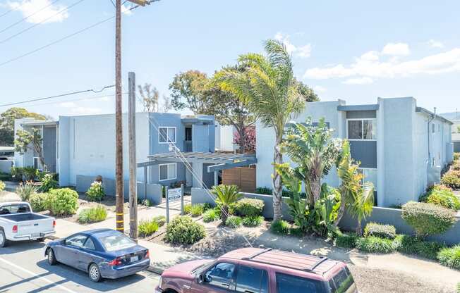 A car is parked on the street in front of a house.