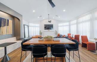 A modern dining room with a wooden table and black chairs.