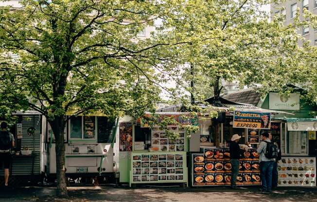 a row of food trucks on the side of a street