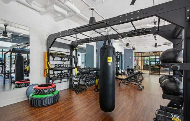 a gym with weights and cardio equipment on the walls and a wood floor at Link Apartments® 4th Street, Winston-Salem, 27101