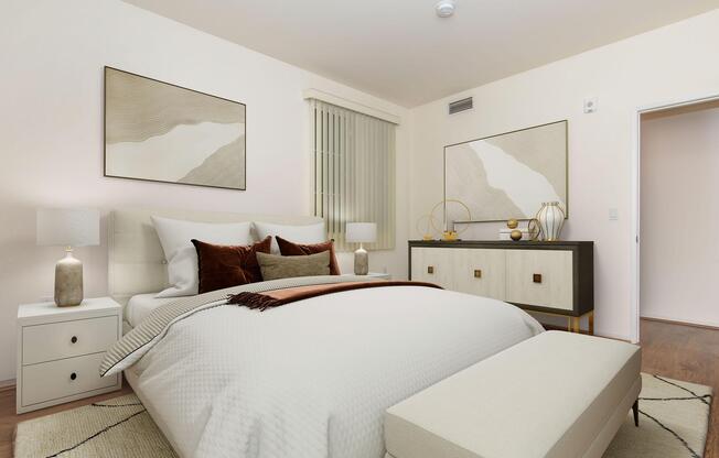 Cozy, modern bedroom featuring a light color palette with a large upholstered bed adorned with decorative pillows. Two minimalist art pieces hang on the wall, and a stylish dresser sits across from the bed, complemented by side tables and contemporary decor items. Natural light flows through a window adorned with vertical blinds.