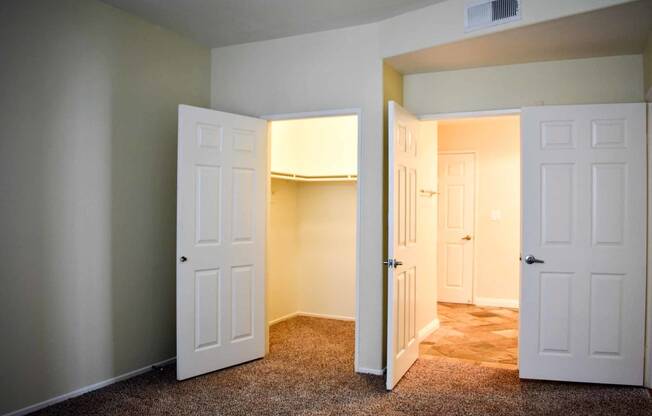 View from bedroom  with carpet flooring into walk in closet and into ensuite bathroom with tile flooring