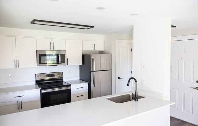 a kitchen with white countertops and a sink and a refrigerator