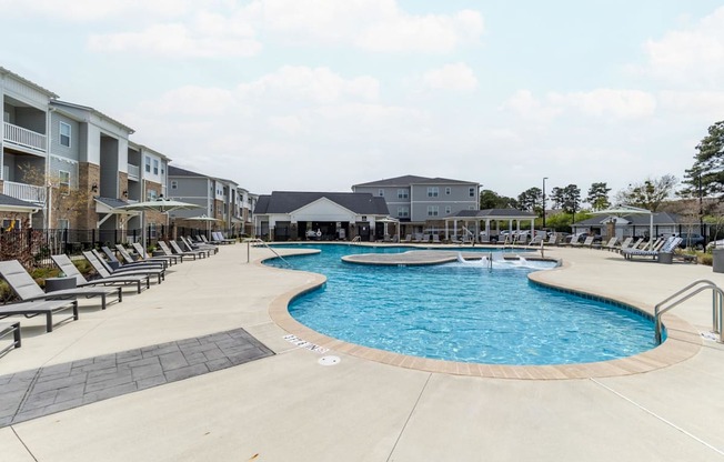 a resort style swimming pool with lounge chairs around it