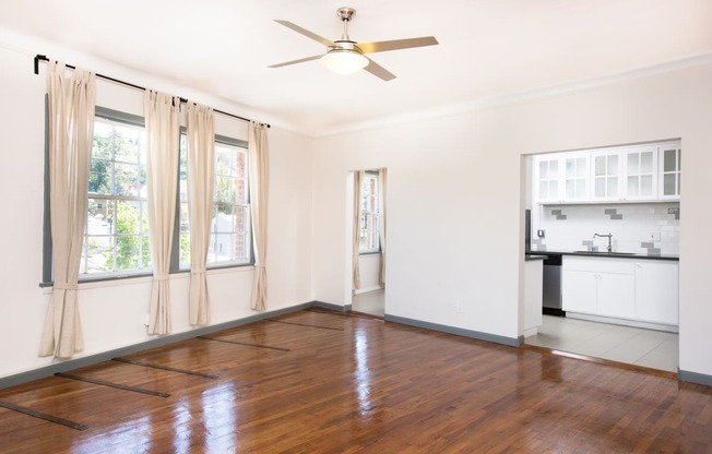 an empty living room with hardwood floors and a ceiling fan at Del Mor, Los Angeles