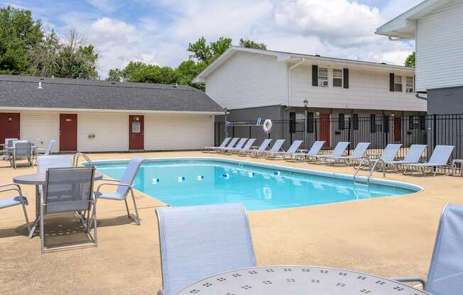 A pool with chairs around it and a building in the background at Spring Creek Townhomes Apartments, Springfield