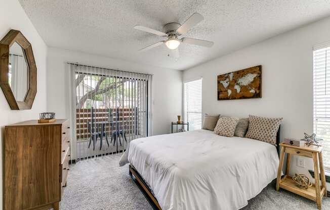a bedroom with a bed and a ceiling fan