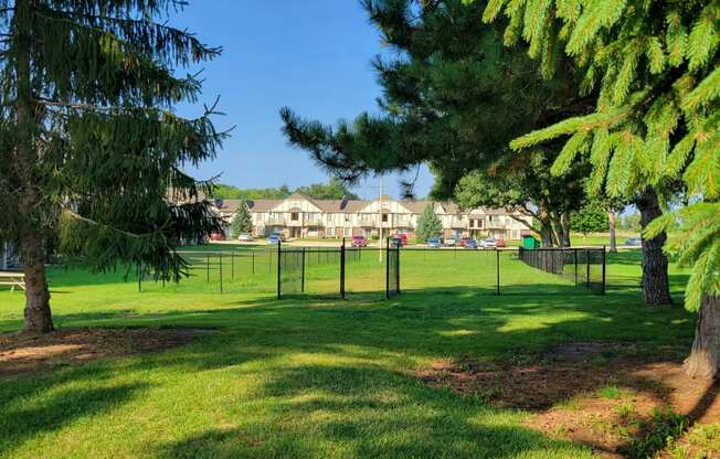 a large grassy area with trees in the foreground and houses in the background at Beacon Hill and Great Oaks Apartments, Illinois