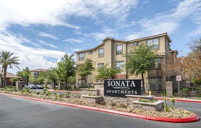 a sign for sonata apartments sits in front of a parking lot
