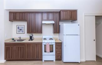 Apartments Daly City-Brunswick Street Kitchen with Modern Lighting, Matching White Appliances, and Hardwood Styled Floors