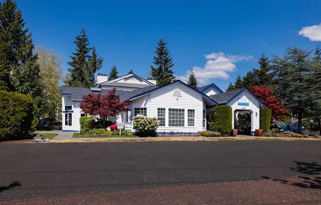 A white house with a red roof and a blue sign on the front.