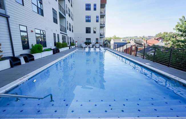 A swimming pool in a residential area with buildings in the background.