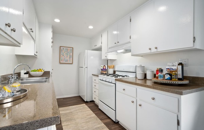 a kitchen with white cabinets and white appliances