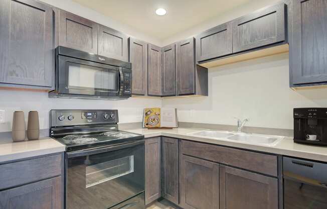 a kitchen with black appliances and wooden cabinets at Madison Park, Montana, 59718