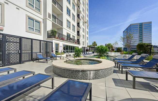 Rooftop pool and hot tub with lounge chairs at Dominion Post Oak apartments in Houston, TX