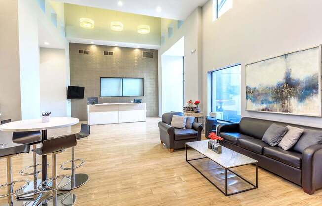A modern living room with a black leather couch and a white coffee table.