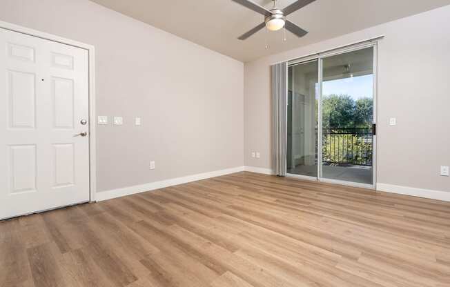 a living room with wood flooring and a ceiling fan