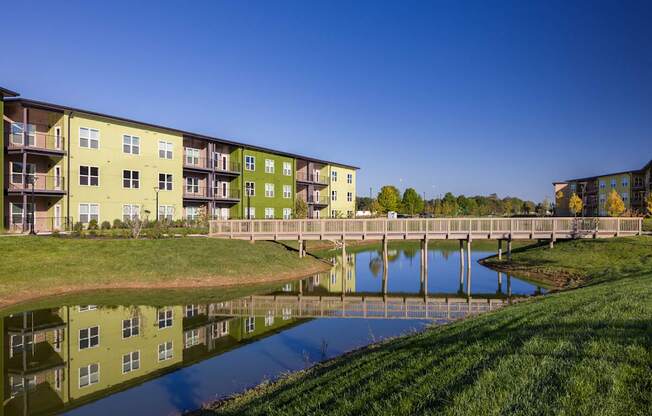 A bridge crosses a body of water in front of apartment buildings.