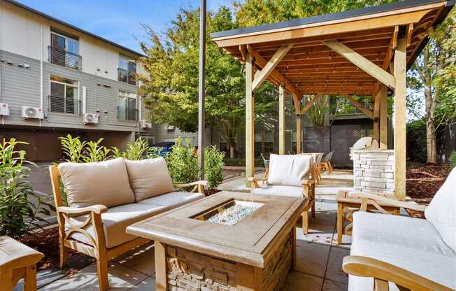 A wooden patio with a couch, chairs, and a table.