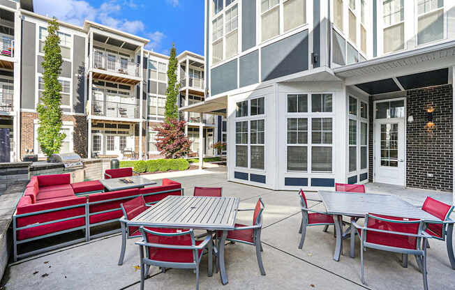 A patio with a table and chairs is surrounded by apartment buildings.