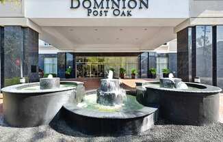 Main entrance to lobby with a fountain feature at Dominion Post Oak apartments in Houston, TX.