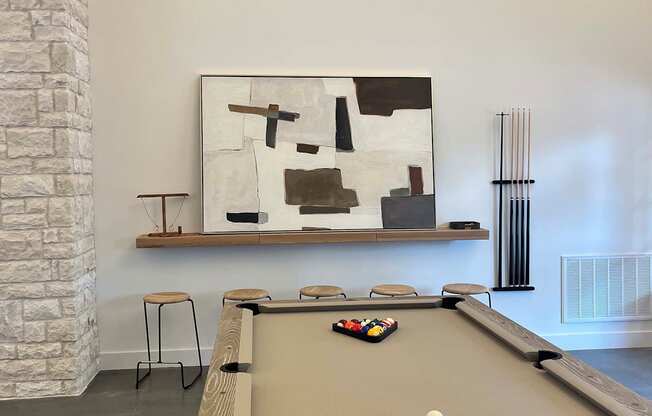 a pool table in a room with a painting on the wall