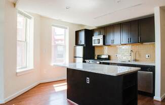 a kitchen with black cabinets and a white counter top