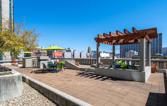 a rooftop patio with a pergola and a view of the city