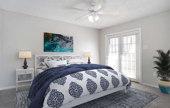 a bedroom with a bed and a ceiling fan
