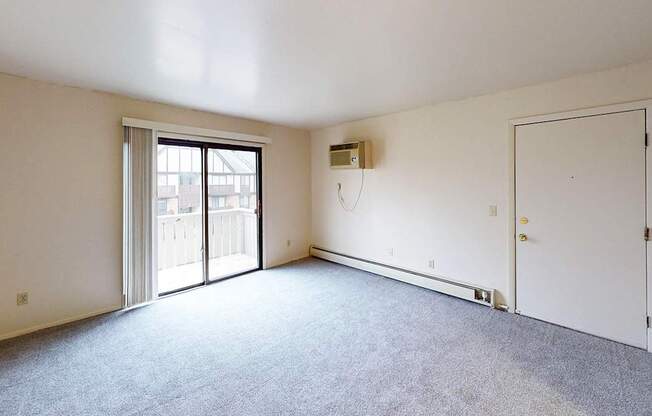 A carpeted living room with a slider to a private balcony at Glen Oaks Apartments, Michigan, 49442