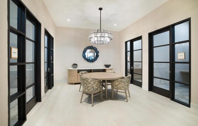 A private meeting room with a round table and glass-front offices, offering a polished setting for focused work or small group collaboration.