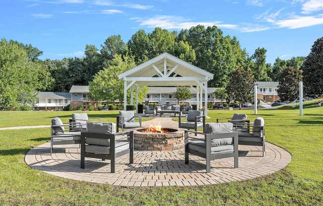 a patio with chairs and a fire pit in a park