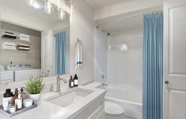 a bathroom with white walls and a blue shower curtain