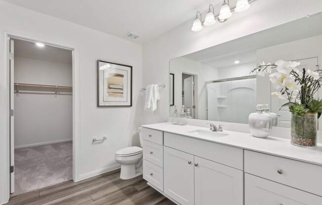 a bathroom with white cabinets and a white toilet