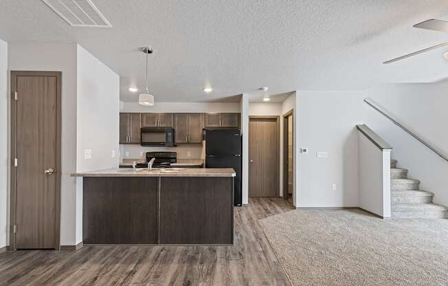 Modern open-concept kitchen and living area with black appliances.