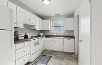 Element at 4411 Macon Apartments A kitchen with white appliances and cabinets.