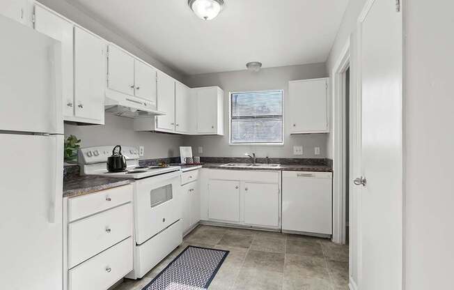 Element at 4411 Macon Apartments A kitchen with white appliances and cabinets.