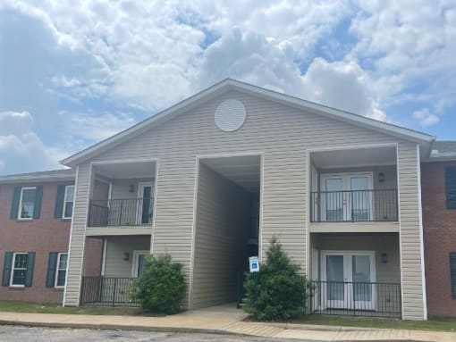 the outside of an apartment building with balconies and a cloudy sky