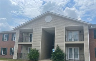 the outside of an apartment building with balconies and a cloudy sky