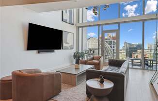 living room with leather furniture and a large window with a view of the city