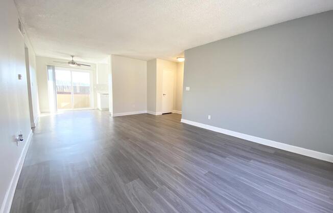 the living room and dining room of an apartment with wood flooring
