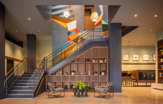 the lobby of a hotel with a staircase and chairs