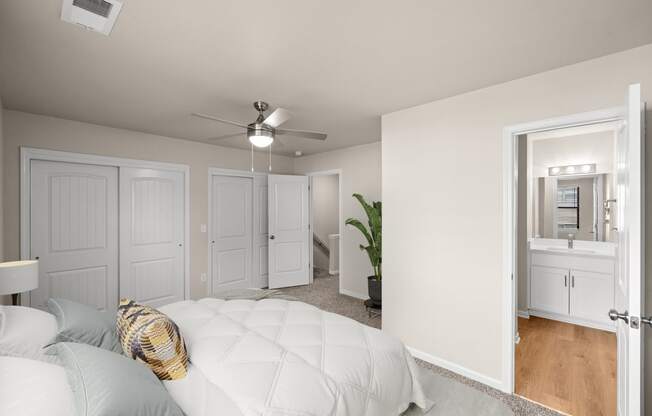 a bedroom with a white bed and a ceiling fan