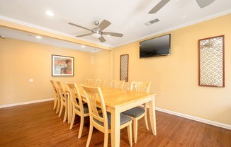 a dining room with a table and chairs and a flat screen tv at Sagewood Gardens Senior Apartments, Hacienda Heights, CA