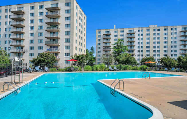 a swimming pool with an apartment building in the background