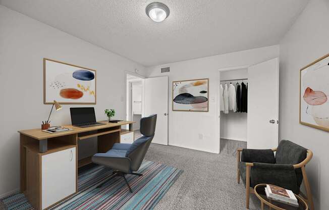 A room with a desk, chair, and artwork on the wall.