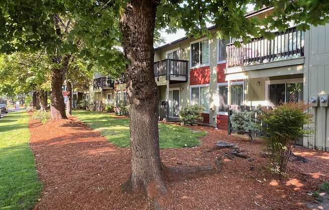 an apartment building with trees and grass in front of it