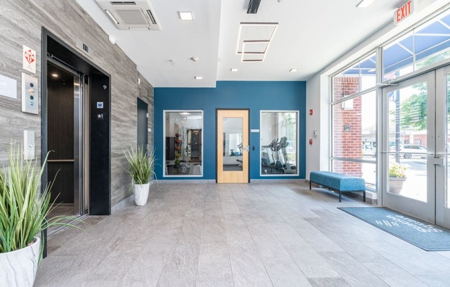 a large lobby with a bench and glass doors