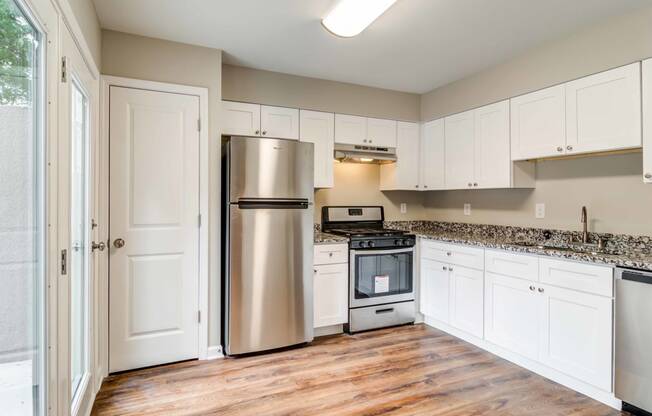 Mirador at Idlewood Apartments in Clarkston Georgia photo of kitchen with white cabinets and stainless steel appliances